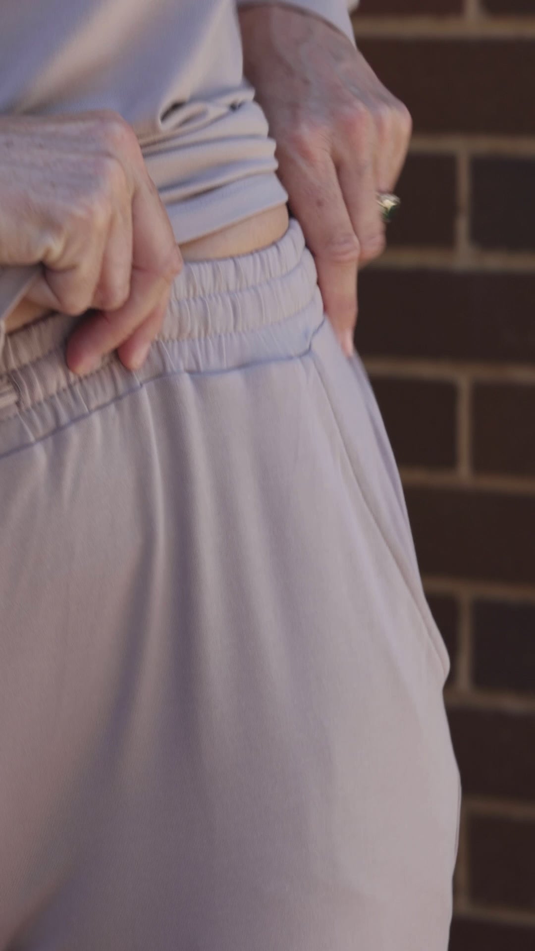 video showing the details of the taupe travel pants with elastic waistband and side pockets