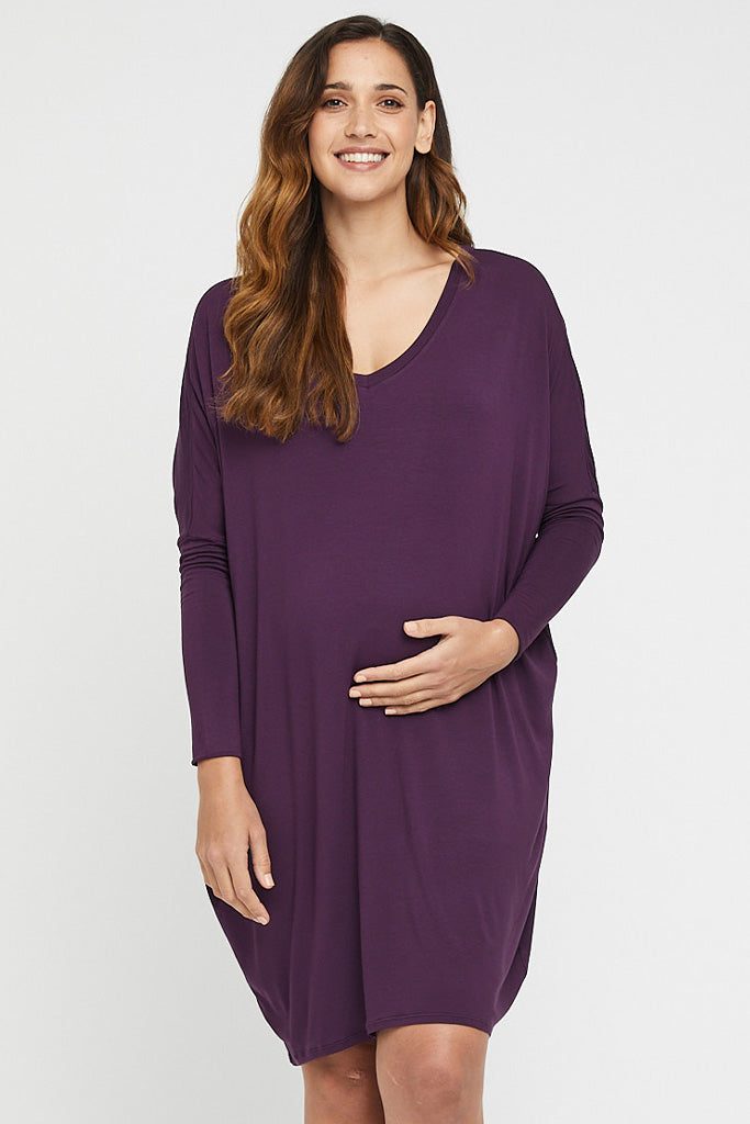 Oversized maternity dress in purple featuring long sleeves and v neckline.