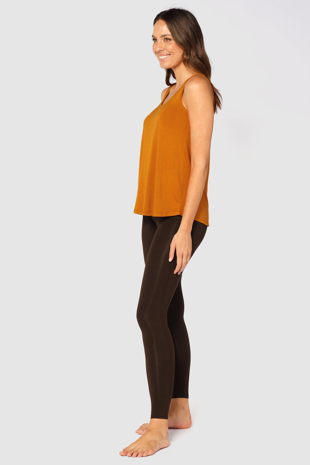 A side view of the model wearing dark brown bamboo leggings