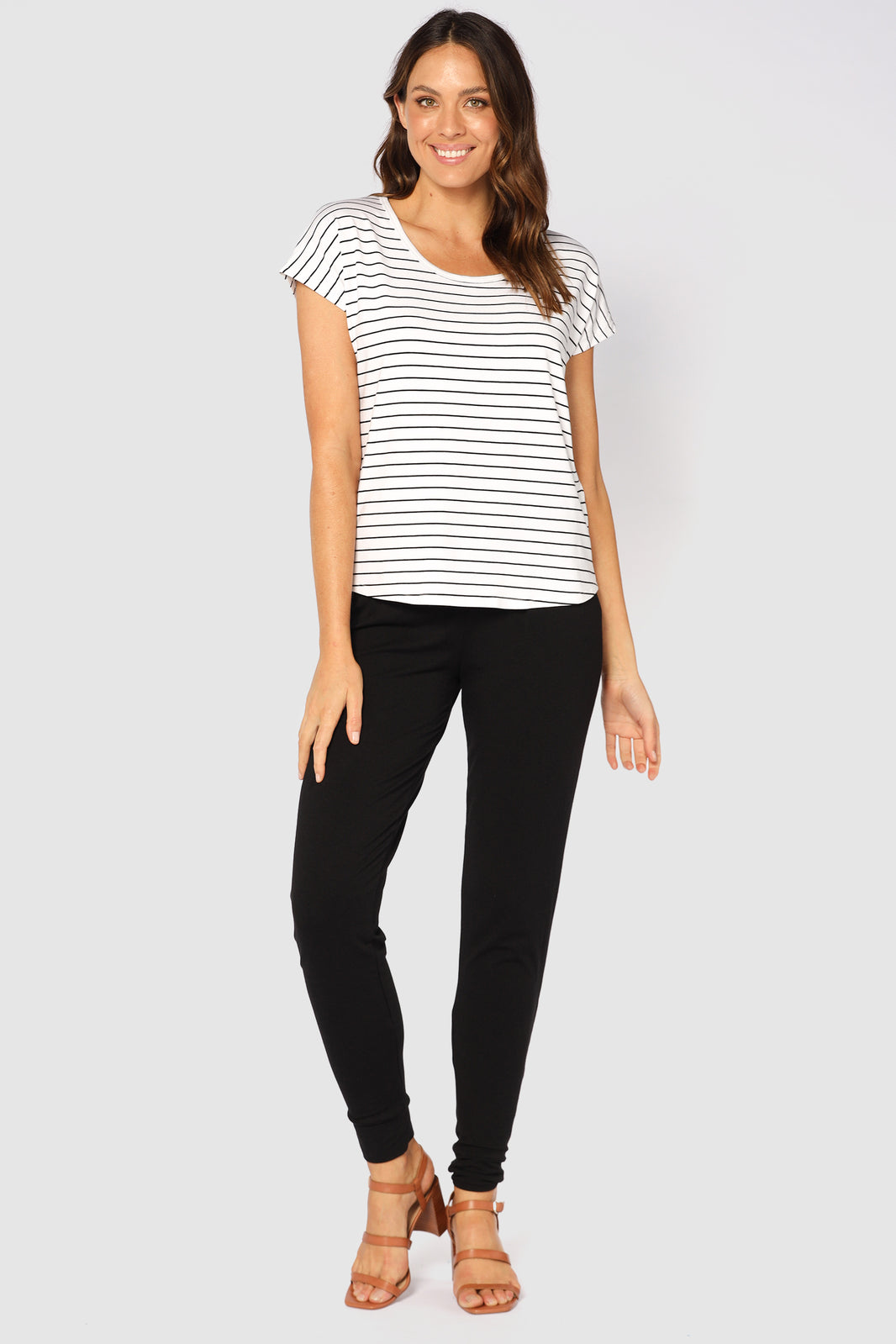 A woman wearing black bamboo slouch pants with cuffed ankles