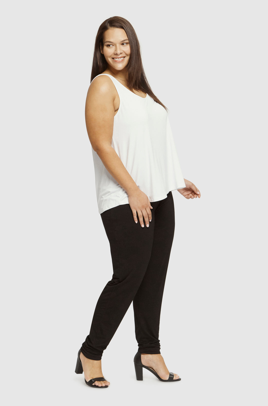 a plus size model wearing black slouch bamboo pants with cuffed ankles