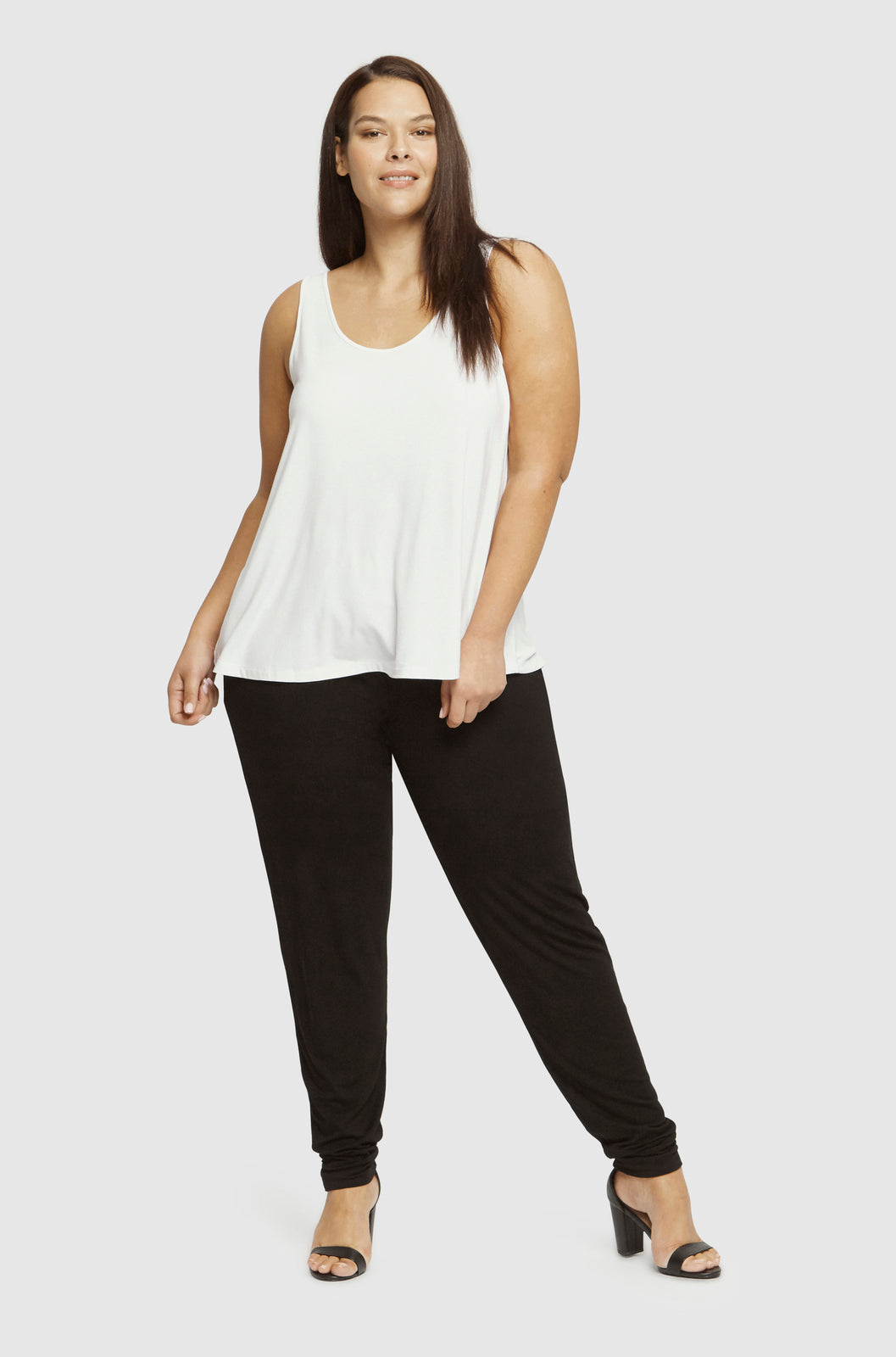 a plus size woman wearing black slouch bamboo pants with cuffs at the ankles