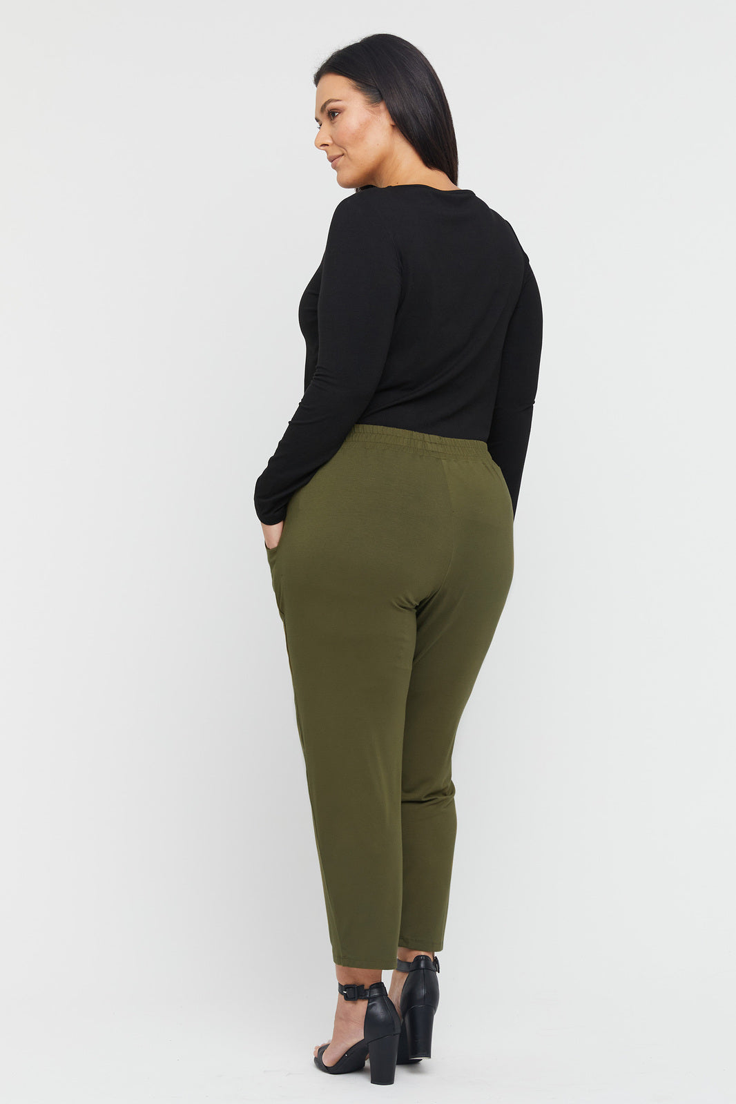 a back view of the peggy pants in dark olive with side pockets and a soft elastic band
