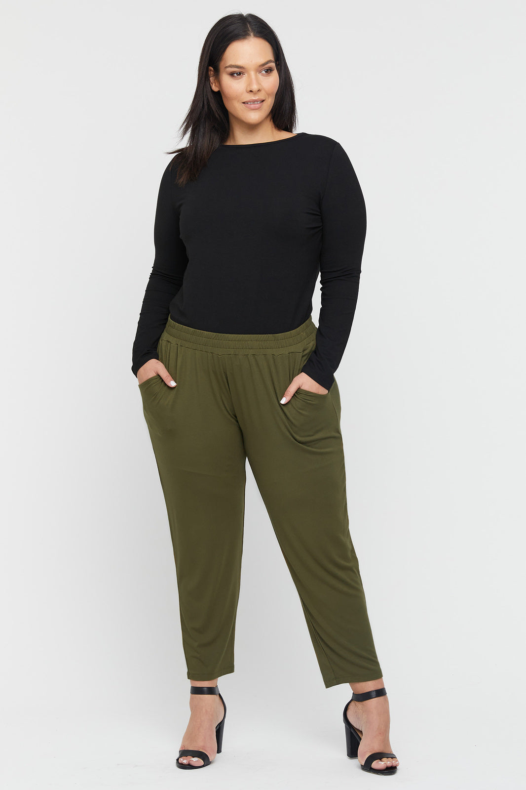 A model wearing dark olive bamboo trousers with an elastic waistband and side pockets, paired with a black top.