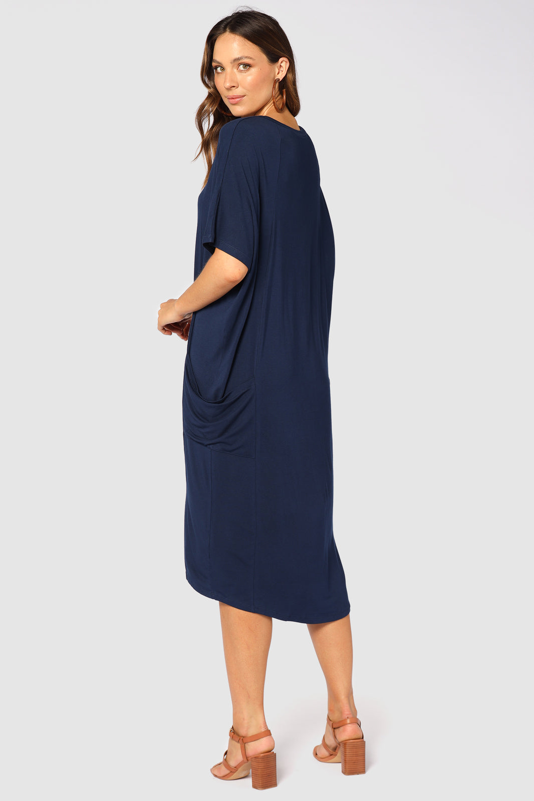 Back view of navy bamboo dress with side pockets and batwing sleeves.