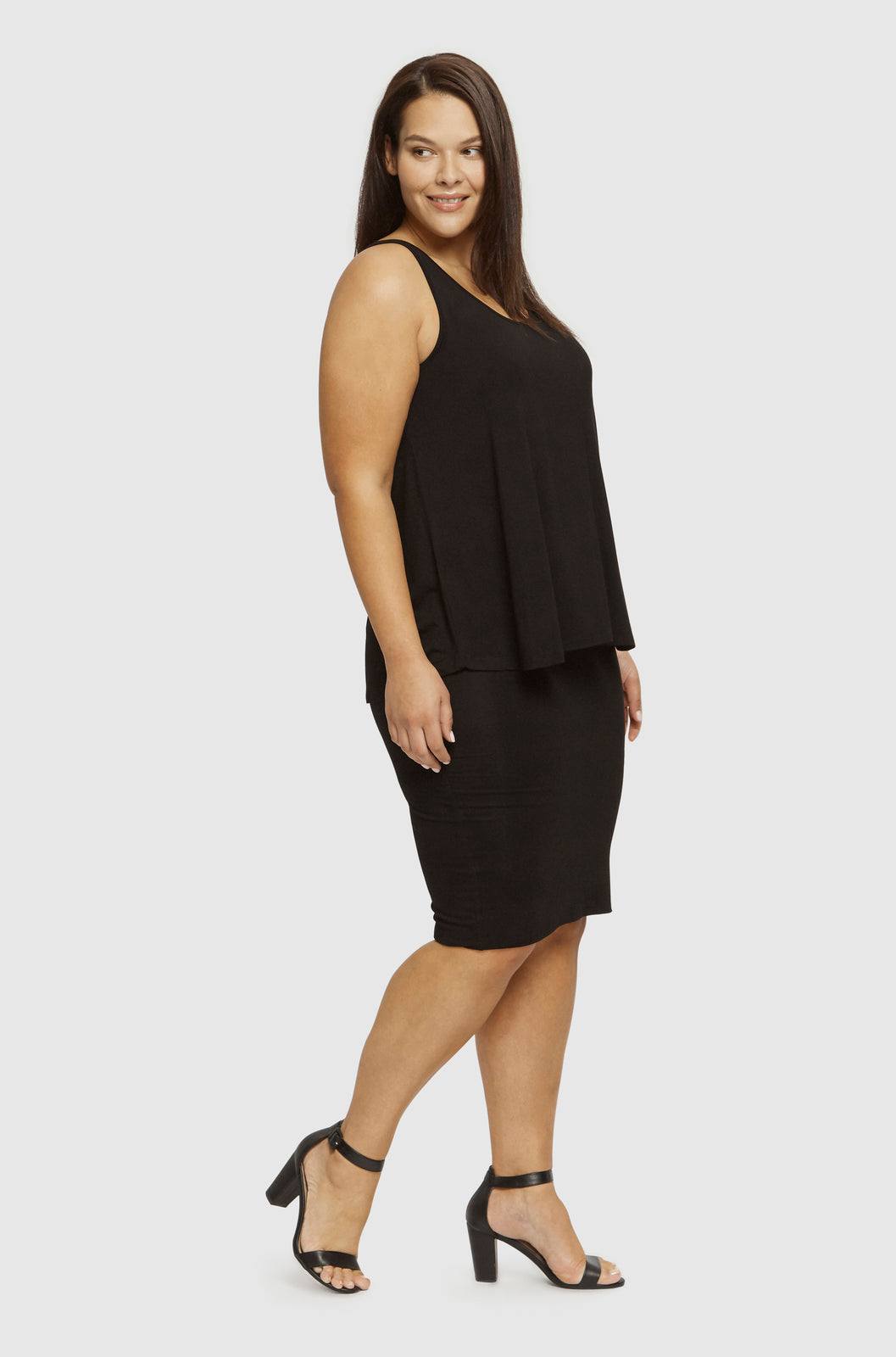 Side image of plus size model wearing relaxed singlet in black with black skirt