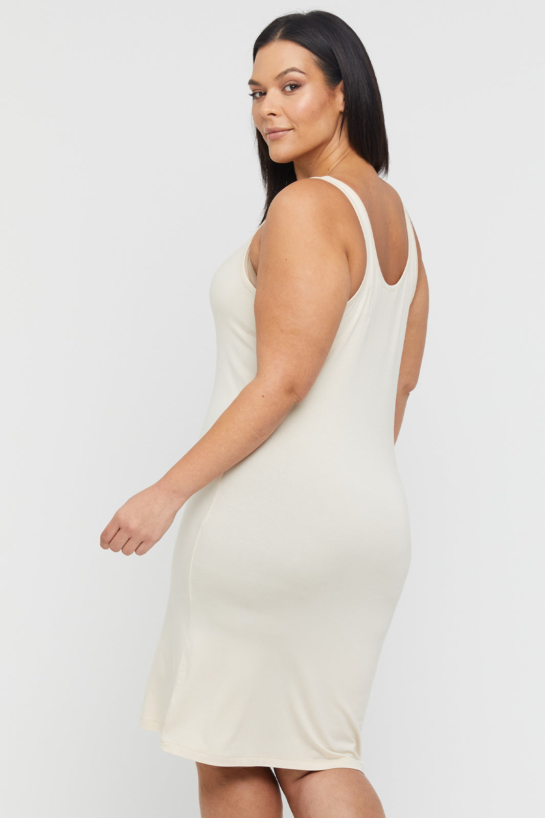 Back view of curvy model wearing a beige bamboo knee length dress