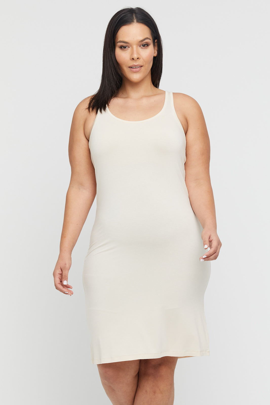 Curvy model wearing a beige sleeveless dress