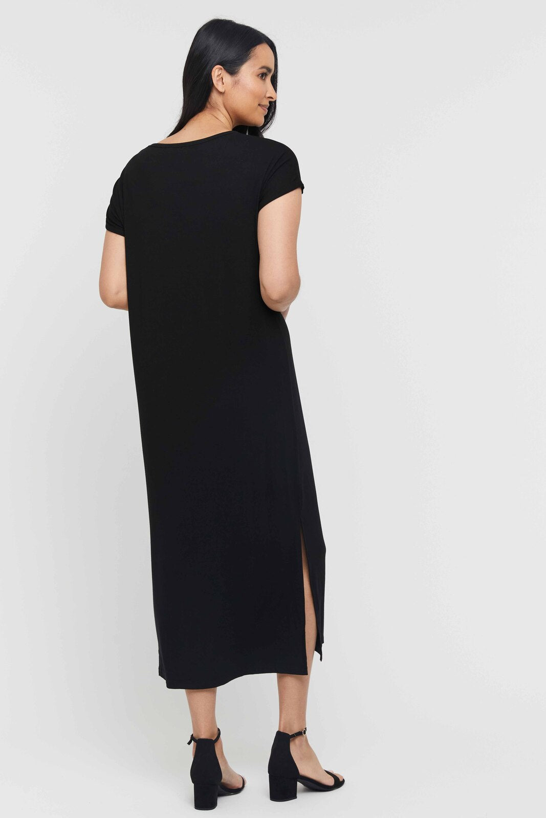 Back view of black bamboo maxi dress styled on model with short rolled hem sleeves