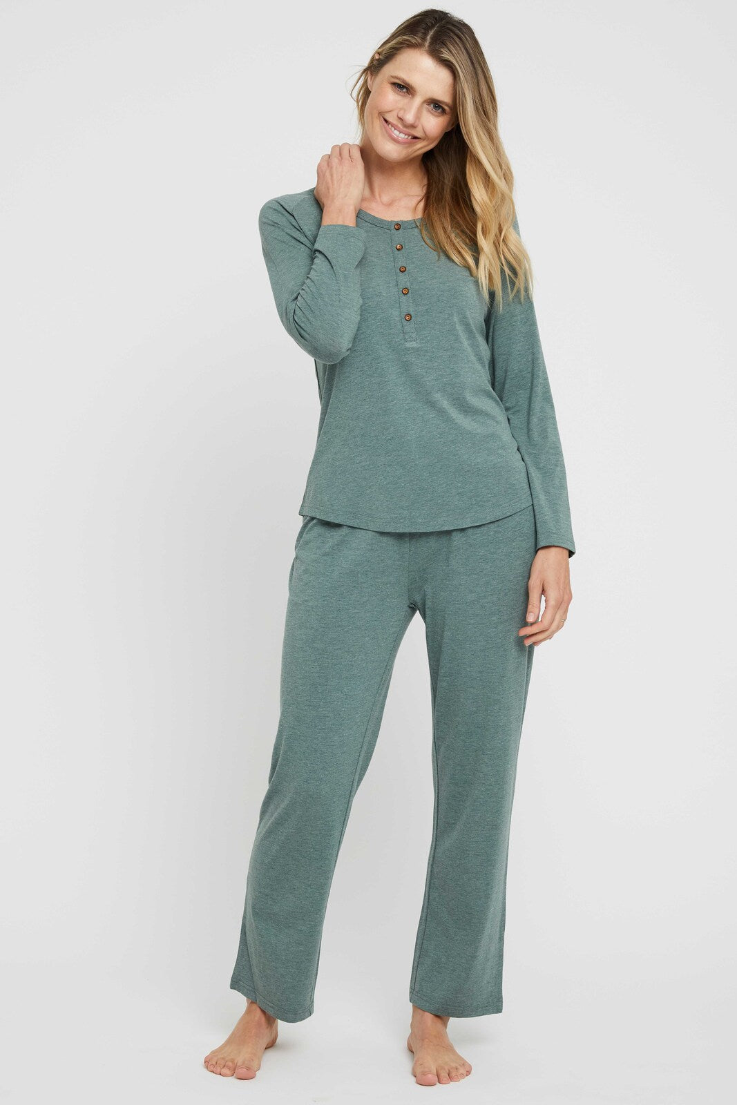 Model wears a pair of green bamboo pyjama pants which feature a straight leg and have a relaxed silhouette.