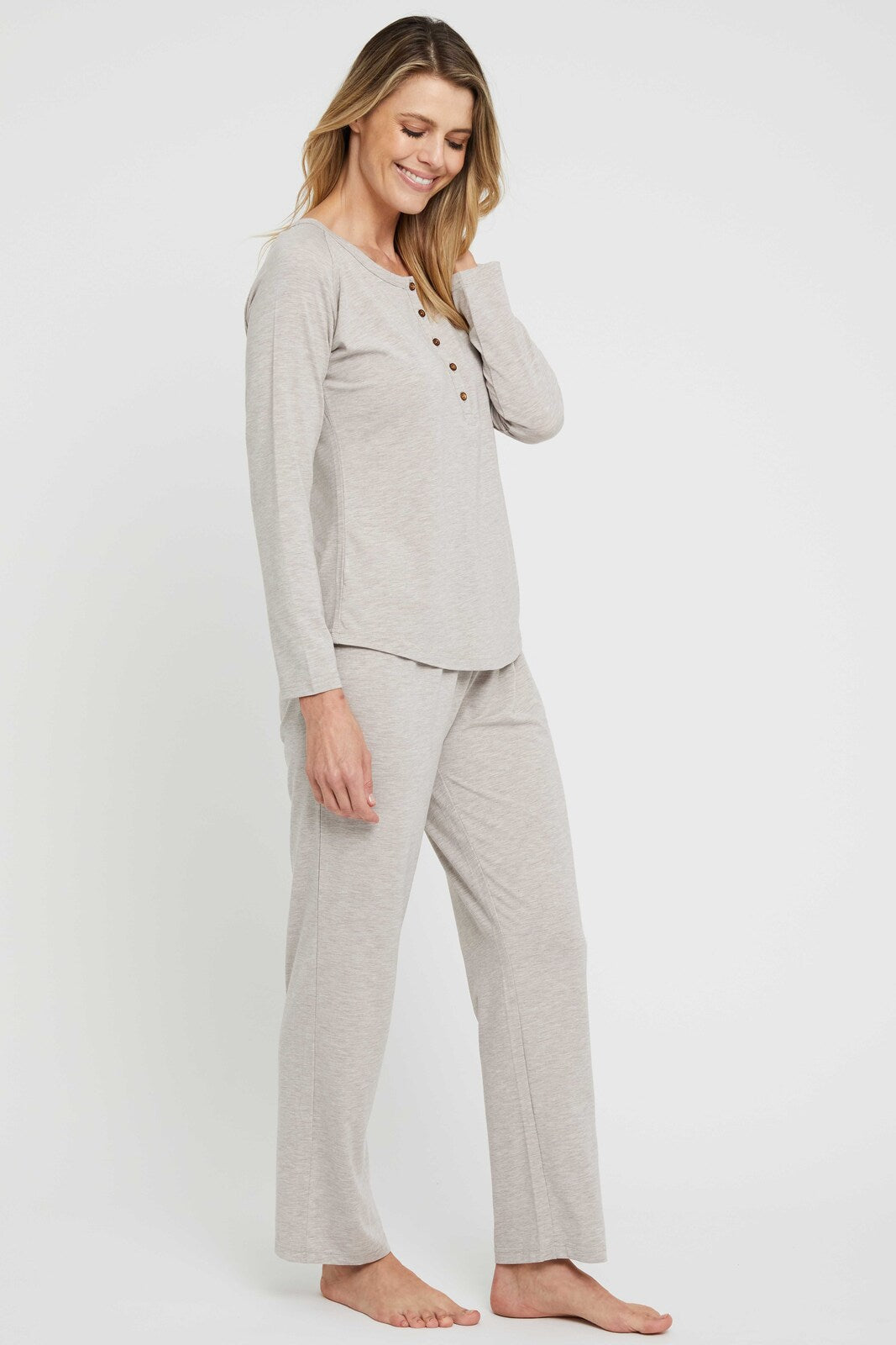 Side view of model wearing a pair of lightweight beige pyjama pants, ideal for a good night's sleep.