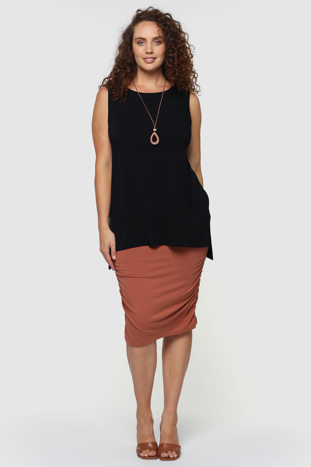 Black sleeveless top with lower hem line on the back and higher on the front.