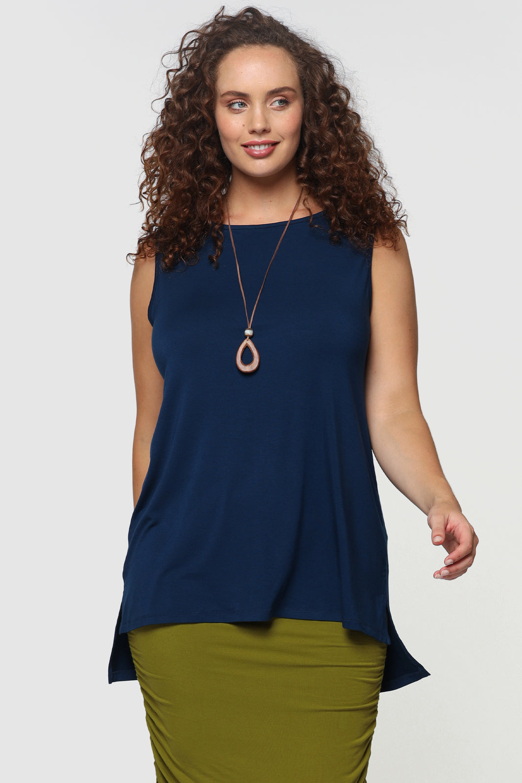 Plus size model is wearing a loose singlet top that's shorter on the front and longer on the back.