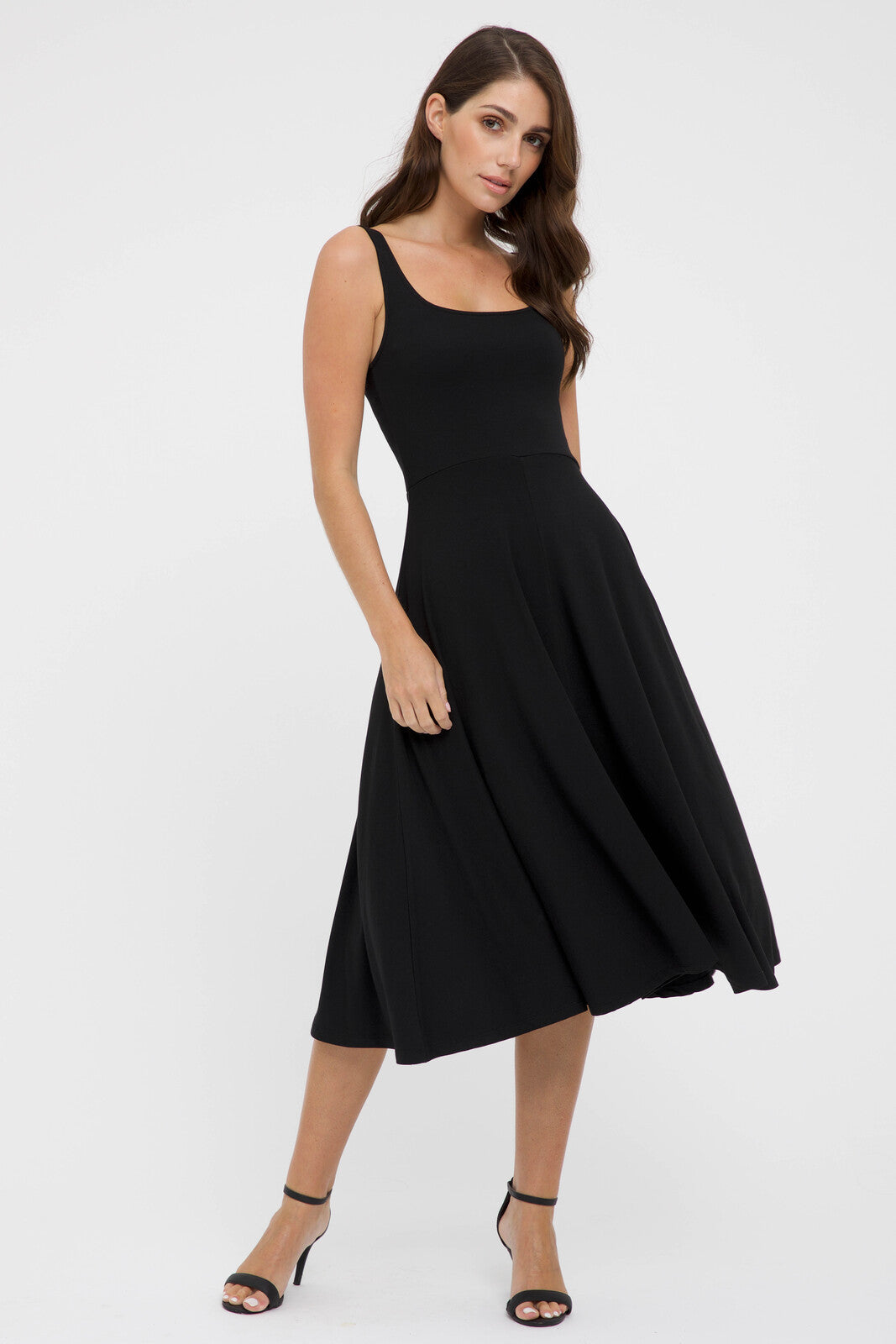 A model wearing a black sleeveless knee-length A-line dress with a square neckline.