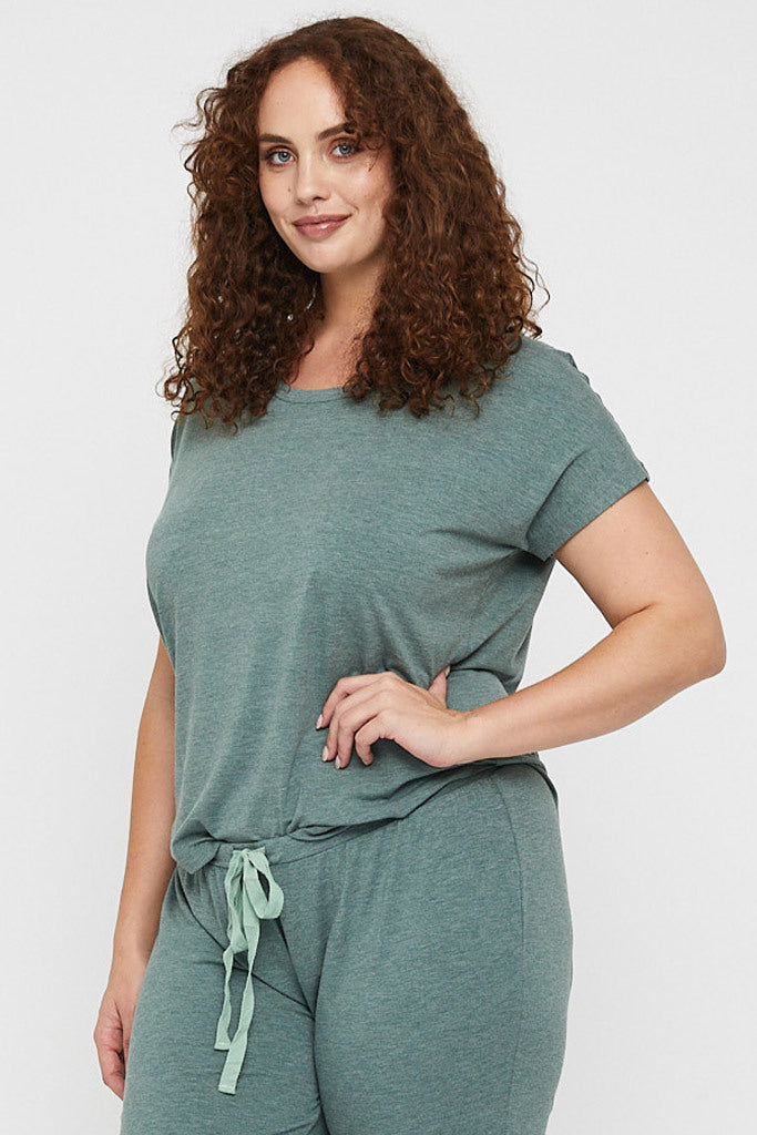 Side view of curvy model wearing a short sleeved green lounge tee made out of hypoallergenic fabric.