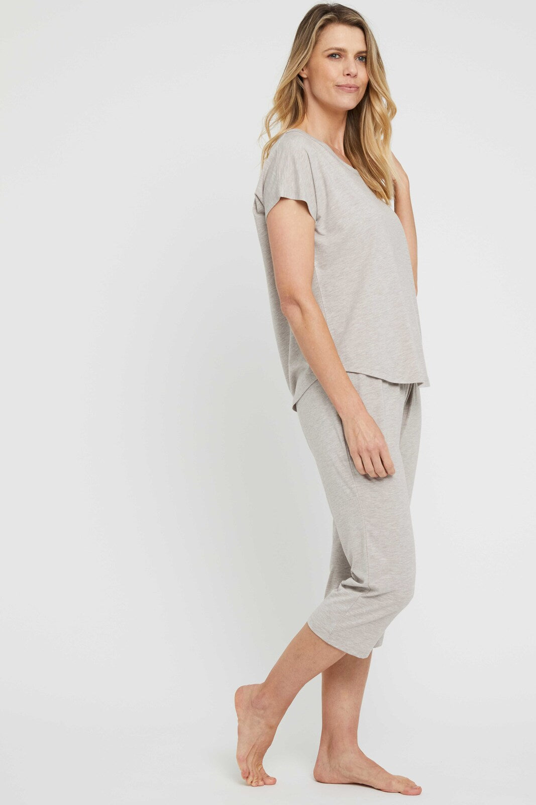 Side view of model wearing a beige relaxed pyjama tee paired with matching bottoms.