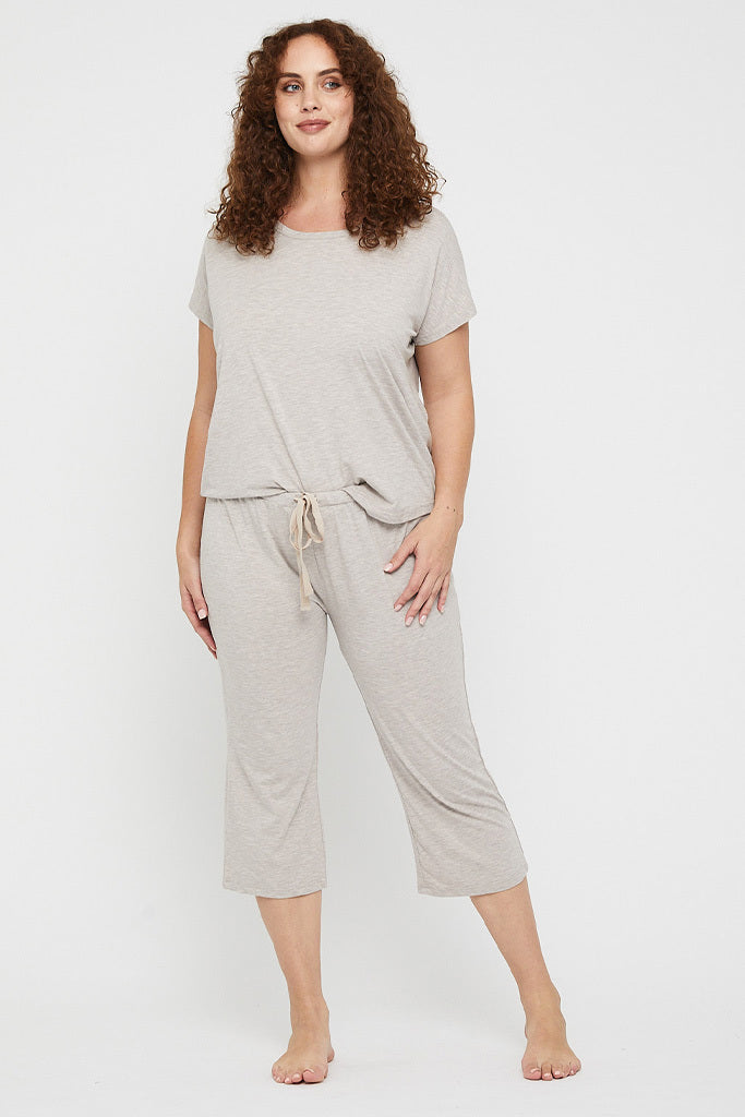 Plus size model wearing a relaxed, short sleeved pyjama tee in beige made out of hypoallergenic fabric.