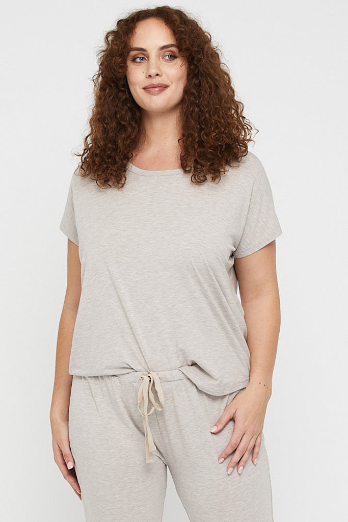 Plus size model wearing a relaxed, oversized beige pyjama tee