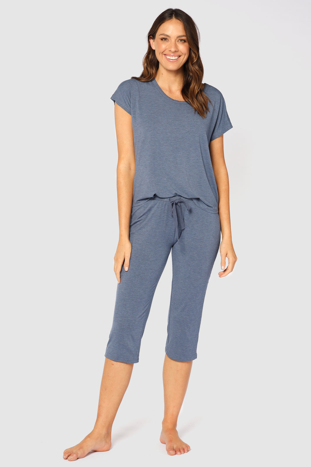 Model is wearing a blue bamboo pyjama top tucked into comfortable matching bamboo pants.