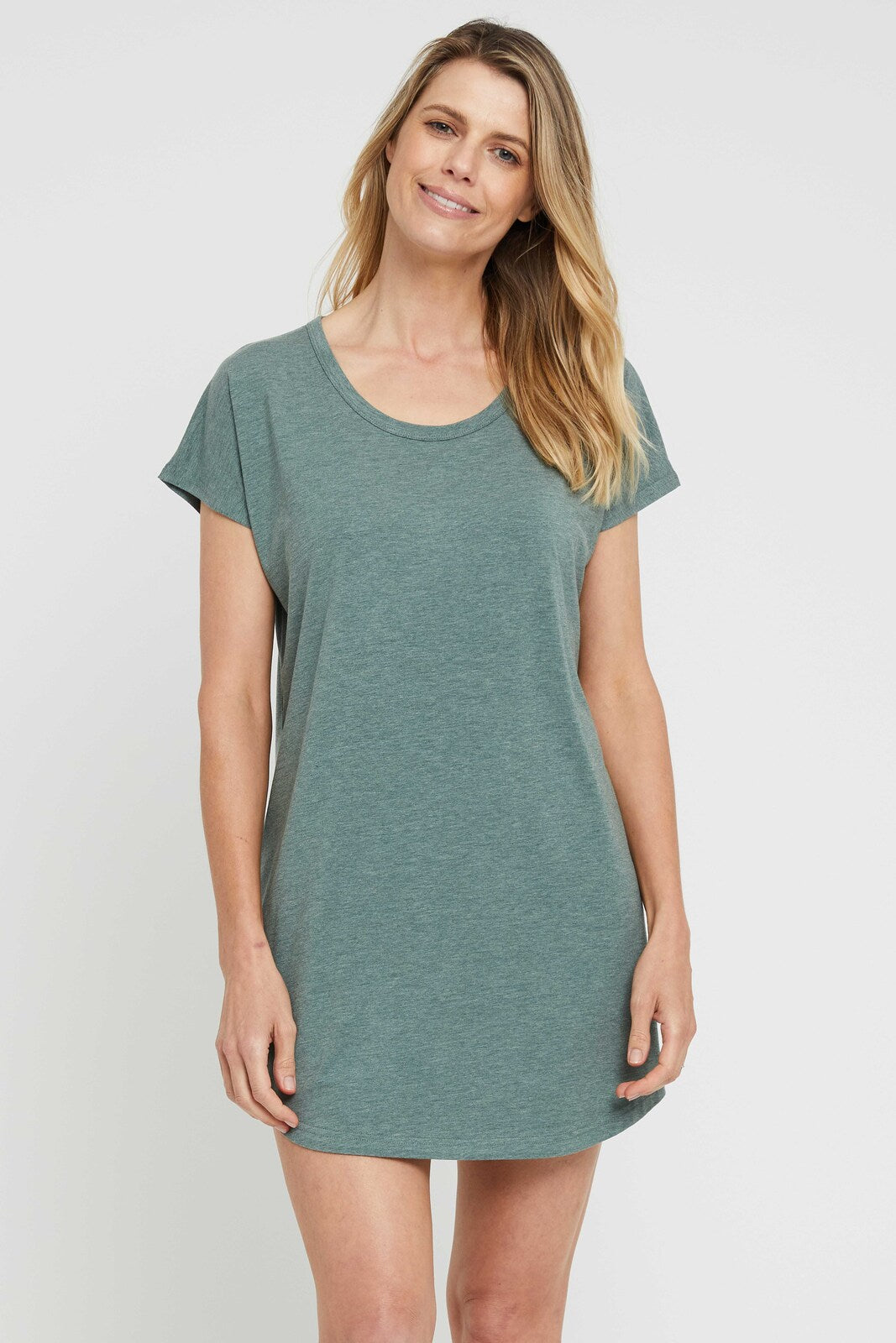 A woman wearing a short-sleeved, knee-length moss green night dress with a scoop neckline.