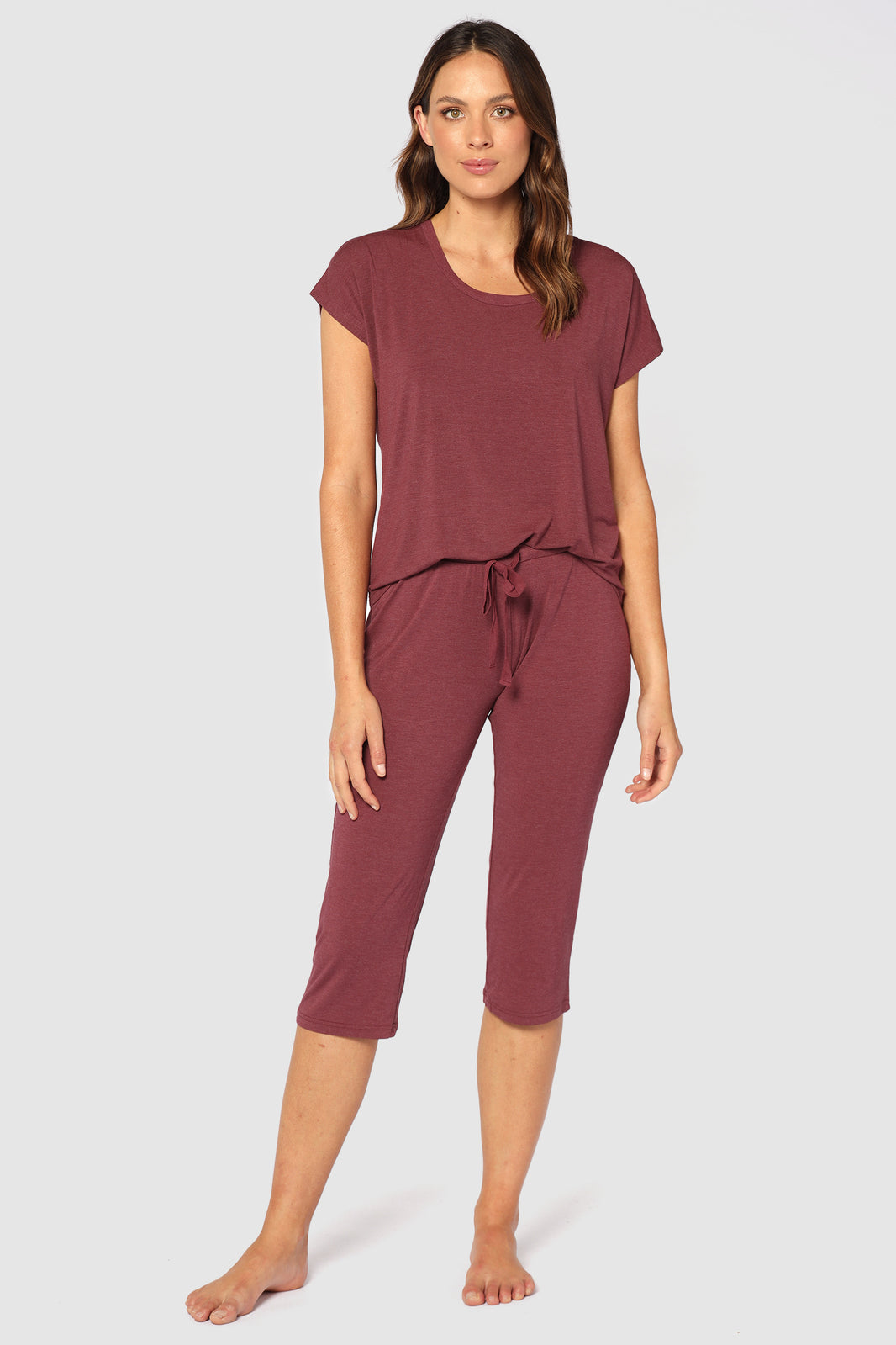 Model wearing 3/4 burgundy pyjama pants paired with matching top.