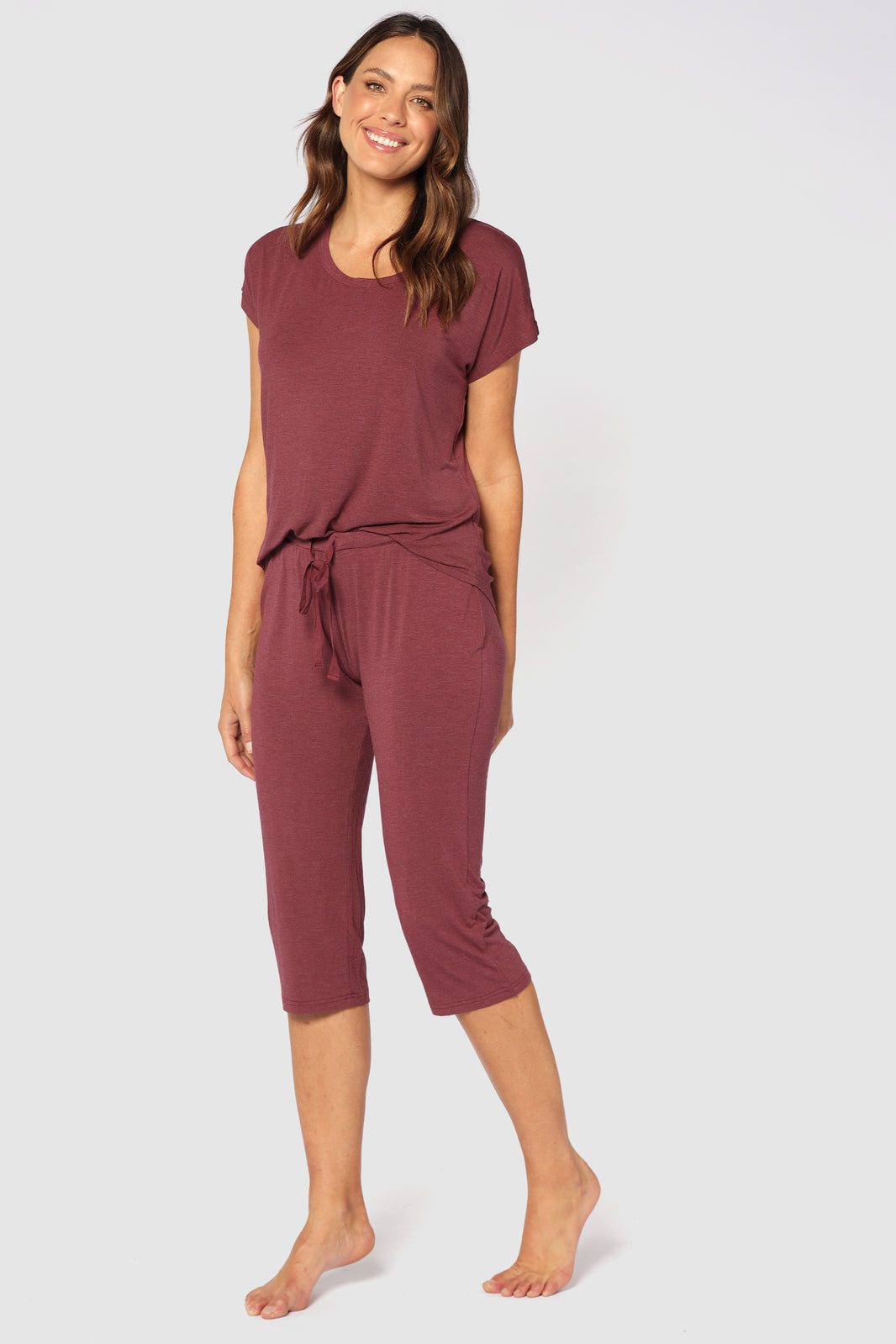 Side view of model wearing 3/4 pyjama pants in burgundy, featuring a straight leg and relaxed fit.