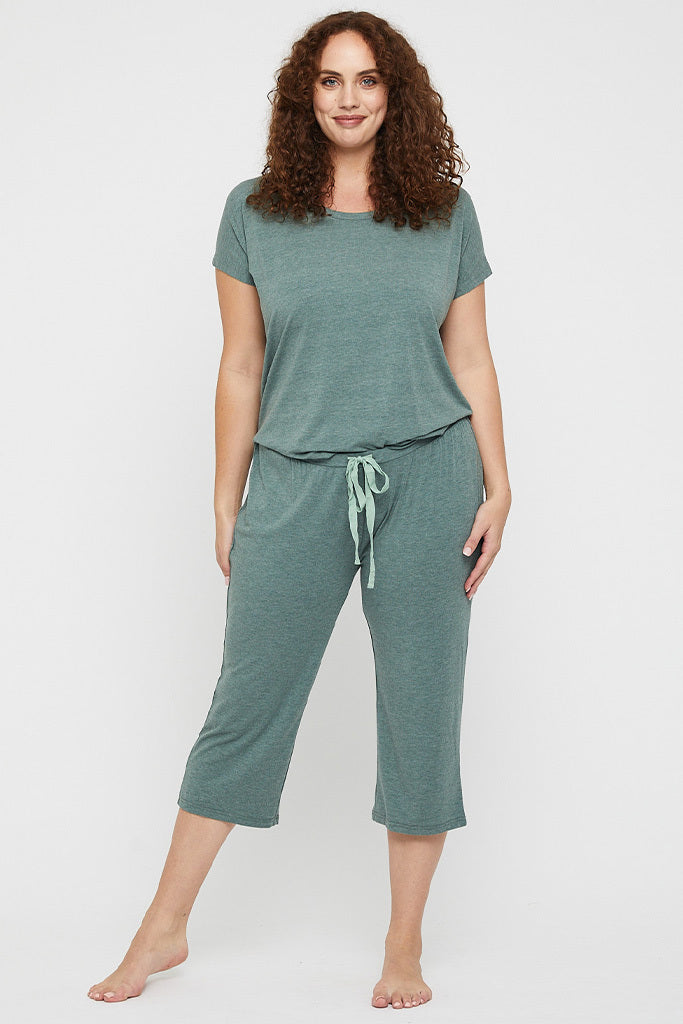 Plus size model wearing stretchy 3/4 pyjama bottoms in green, featuring drawstring and elasticated waistband.