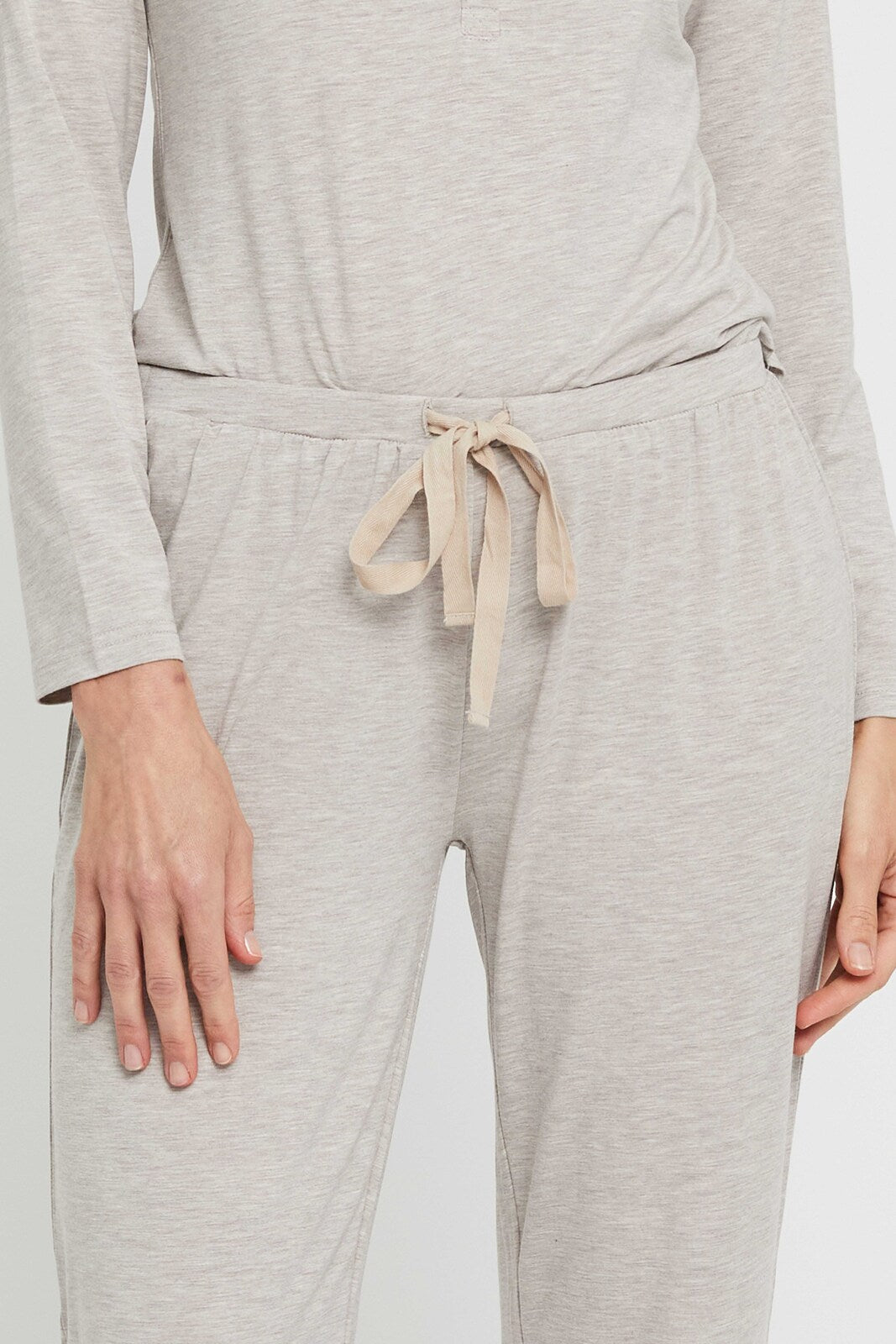 Closeup of elasticated waistband and drawstring on beige pyjama pant.