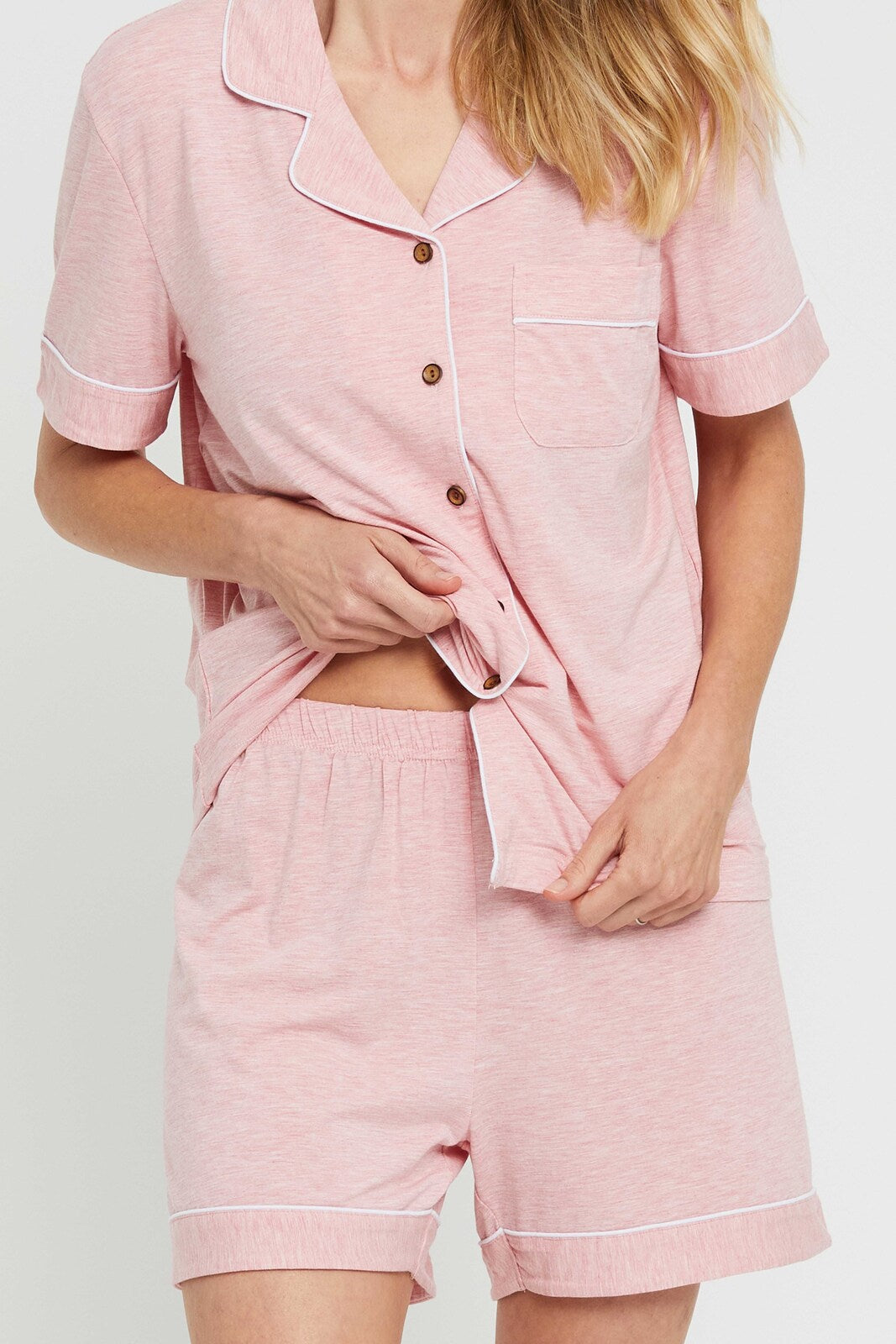 Close up of the pink marle PJ set, featuring a collared shirt with buttons and stretchy shorts with an elasticated waistband.