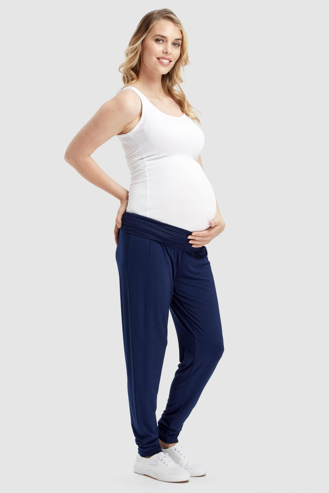 a side view of the bump friendly bamboo slouch pants in the navy shade featuring side pockets, soft wide waistband and cuffed ankles