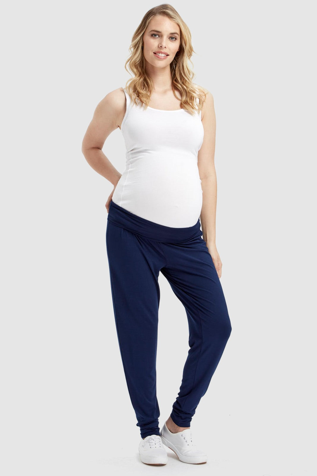 a pregnant model wearing navy bamboo slouch pants with a wide waistband and cuffed ankles